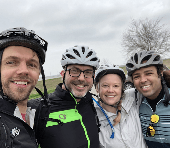 Employees taking a group selfie during an outdoor cycling activity.