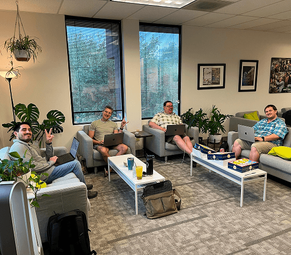 Team members meeting in a lounge-style office space.
